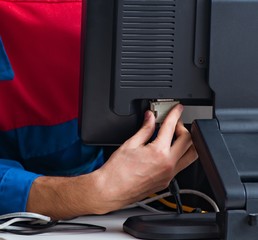Computer repairman working on repairing computer in IT workshop