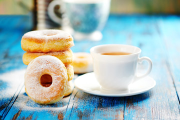 Homemade donuts with tea in the afternoon a wooden blue background.