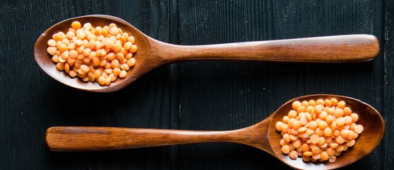 Spoons filled with uncooked lentil for soup