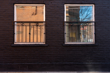 old window with shutters on black building wall