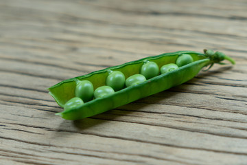 Fresh Green Peas and pods on wood table