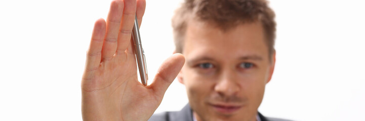 A businessman holds a hand up with a pen at a seminar asks him to give a floor to speak out to make a comment to talk with a lecturer a note on a statement