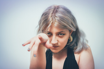 Obraz premium studio portrait of a beautiful girl pointing to the camera