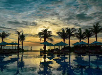 Reflection of palm trees and sky in swimming pool