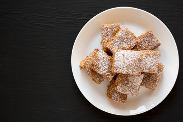 Homemade Tasty Applesauce Cake on a white plate on a black background, top view. Flat lay, from above, overhead. Copy space.
