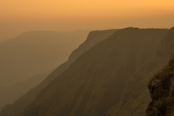 Obraz premium beautiful sunset wit orange tint over the sky and mountains
