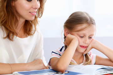 Blond little reading together with mom. Beautiful female young reader, minor baby-sitter, fairy...