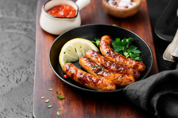 Delicious homemade baked sausages in a frying pan.