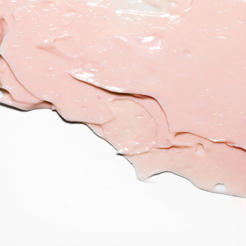Pink cosmetic cream smear on white background. Peach color beauty creme swipe. Skincare product creamy texture. Smudge swatch. Skin care. Mask for the face or body