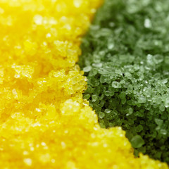 A close-up of loose green and yellow bath sea salt. Texture. Background. Body skin care and spa concept
