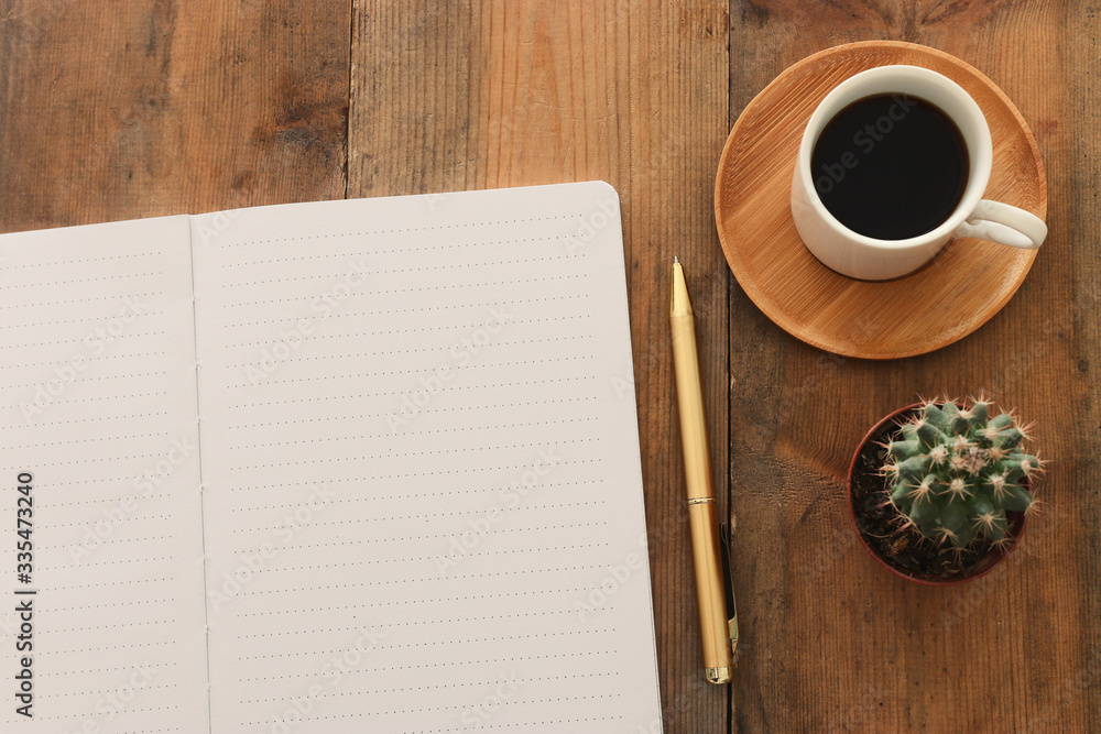 Fototapete top view image of open notebook with blank pages next to cup of coffee on wooden table. ready for ad