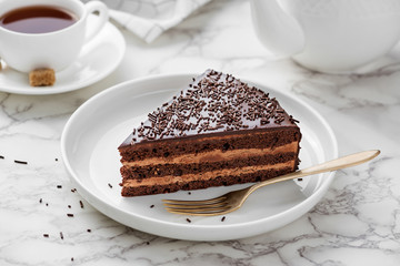 Yummy layered chocolate cake on a white plate.