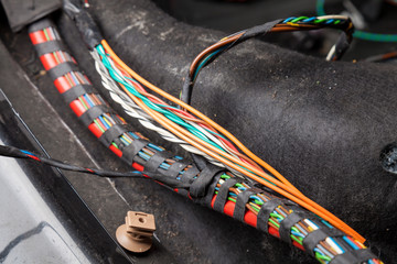 Large wide cable with multicolored orange and green wires, connectors and terminals in the wiring...