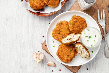 Delicious crispy fried breaded chicken patties with sauce.