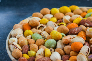 Fototapeta na wymiar Nuts in bowls on the table, almonds, cashews and coasted nuts on the blue background.
