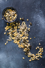 Sunflower and pumpkin seeds  in bowl on the blue background.  Large group of seeds. Snack and appetizer. 