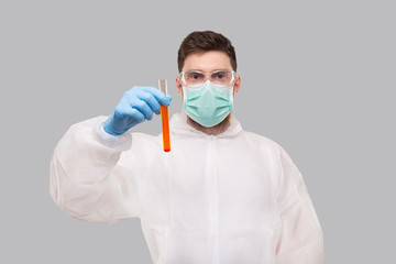 Male Laboratory Worker Showing Blood Analysis Wearing Medical Mask, Gloves and Chemical Suit. Virus, Science Concept Portrait