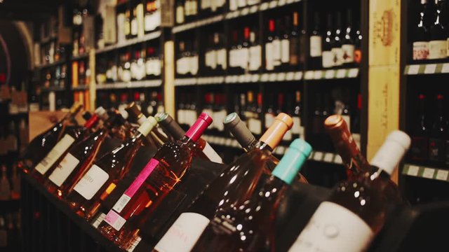 BARCELONA, SPAIN - FEBRUARY 19, 2020: Rack shelves with wine bottles in wine store. Nameplates in Catalan with name of Spanish wine regions 