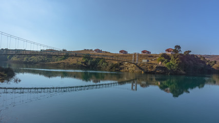 Fototapeta na wymiar Beautiful lake in a country side with a footbridge and resort