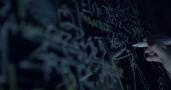 scientist at work writes the formula on the glass