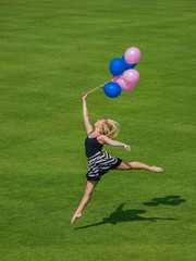 Woman holding ballons jumping