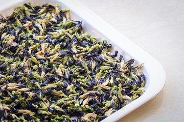 Sun dried butterfly pea flowers In a white plastic tray