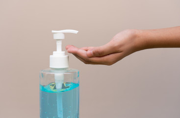Asian girl kid using blue hand sanitizer gel in clear pump bottle , that use for killing germs, bacteria and viruses. Prevent the spread of germs and bacteria and avoid infections corona virus.