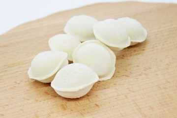 Fototapeta na wymiar Frozen raw dumplings located on a wooden board