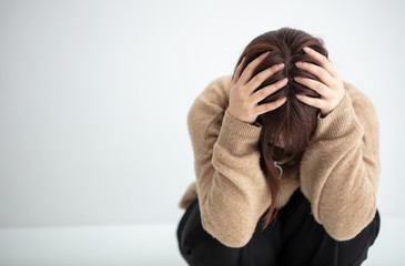 私服の女性が頭を抱えている　悲しい　sad