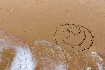 Smile draw on the shore of the sea
