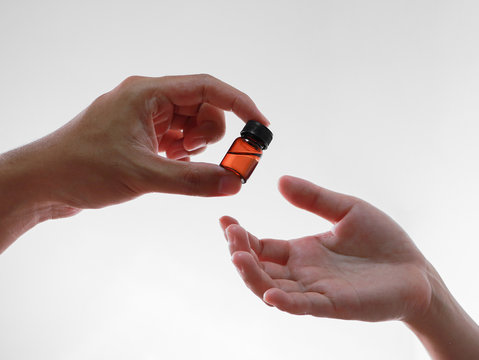 Focus on male hand giving liquid medicine bottle to the patient, corona virus or Covid-19 Vaccine, Medicine and healthcare concept