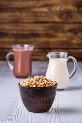 Soy beans and cup of cacao and small creamer on wooden table