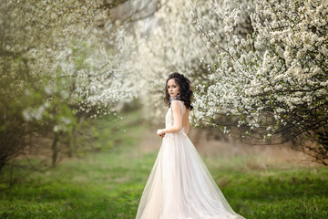 beautiful bride in a wedding dress on a background of blooming gardens, spring, wedding photo session.