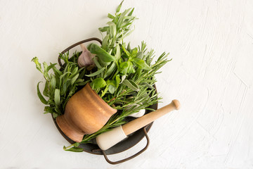 fragrant herbs in a wooden mortar on a gray background