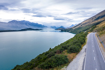 Picturesque scenic drive on winding road from Queenstown to Glenorchy by the Lake Wakatipu on a sunny day.