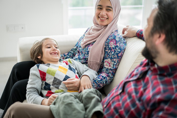 Middle Eastern family sitting on sofa in living roome at home