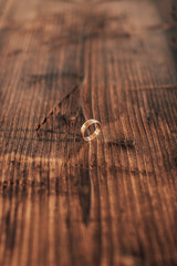 Wedding rings on a dark wooden background.