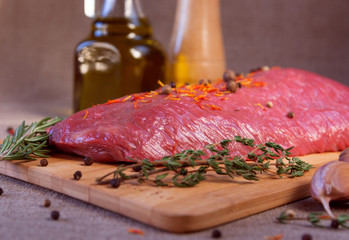 Raw fresh meat with spices on a wooden board