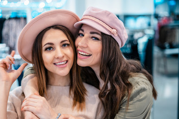 Trade, buyers. Two beautiful girls make purchases in a shopping center, go shopping. The joy of consumption.