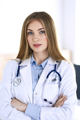 Woman doctor standing in hospital office. Physician at work, life portrait. Medicine and health care concept