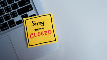 Sorry We' Re' Closed message concept written post it on laptop keyboard.