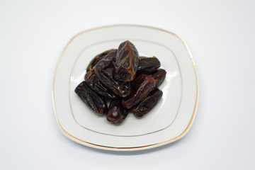 Dates in a dish with a white background