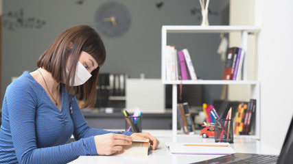 A young girl with mask works on someting at home. because of Covid-19. Working from home icon.