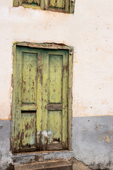 Green color door in the destroyed old house. Architecture detail for background or texture.