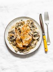 Fried chicken fillet with cheesy mushrooms cream sauce on a light background, top view. Delicious homemade lunch