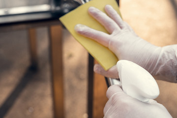 Disinfection of surfaces on the street in the park. Antibacterial treatment, quarantine. Yellow...