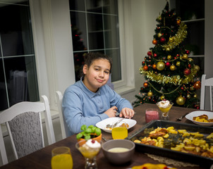 Young boy alone at the dinner table waiting for his family