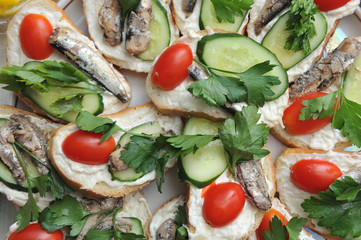 Tasty Appetizer on holiday for guests. Sandwiches with butter, cucumber, parsley and sprats