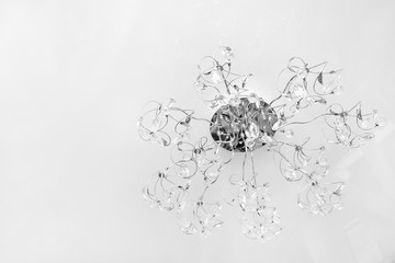 Silver ornate chandelier on a white ceiling background