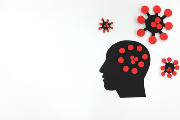 Male head profile in black silhouette with coronavirus paper cutout in white background. Concept of mental health depression and anxiety during covid-19 pandemic.